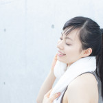 タオルで汗を拭く女性